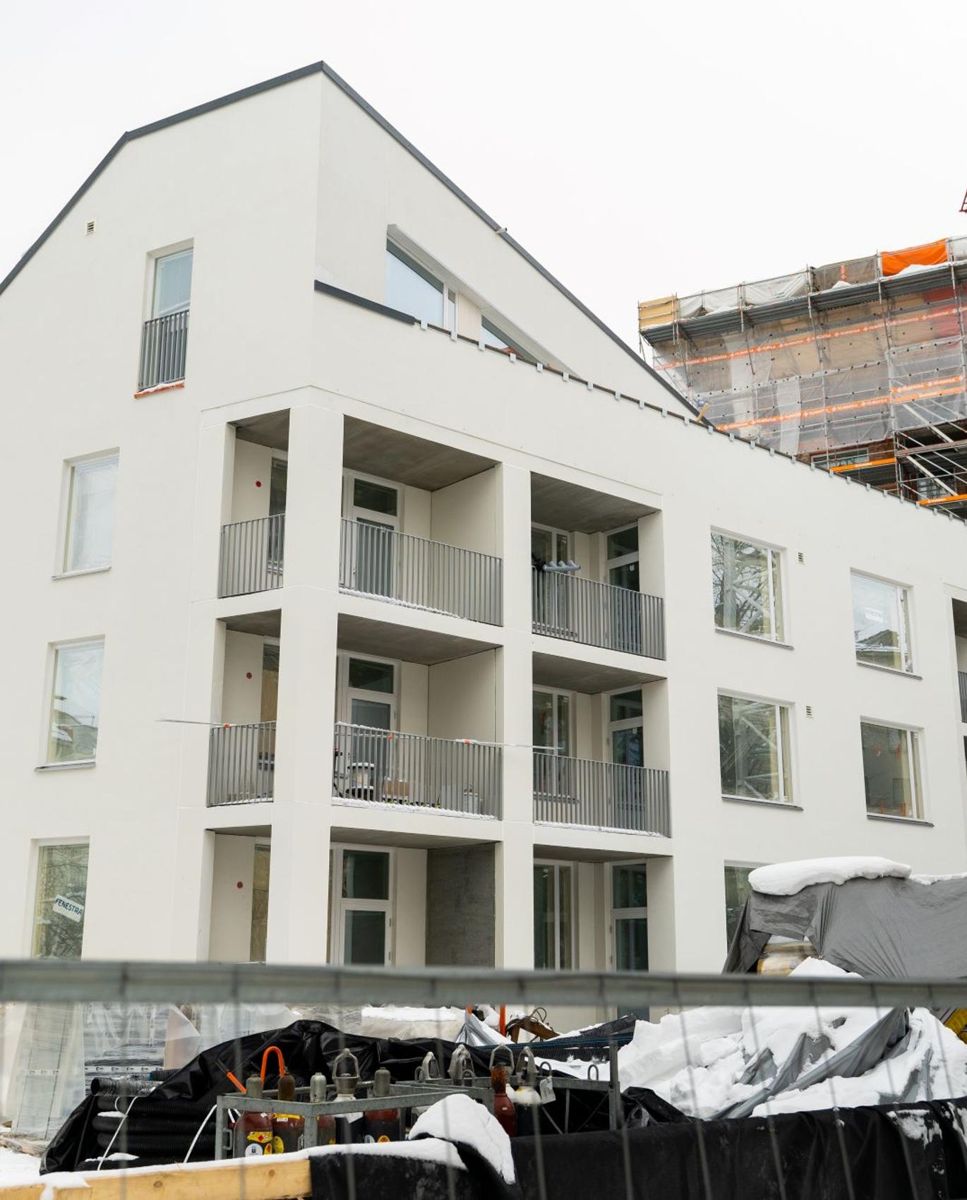 Nurmijärven muurarien työkohde modernissa, valkoisessa kerrostalossa.